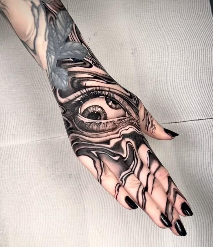 Black-and-grey surreal realism eye tattoo on a hand with a melting marble effect